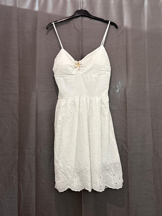 Robe courte blanche en broderie anglaise, bretelles fines et bijou fleur