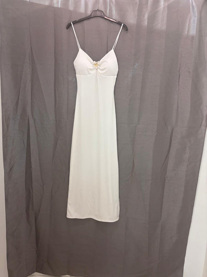 Robe longue à fines bretelles, bijou fleur au décolleté