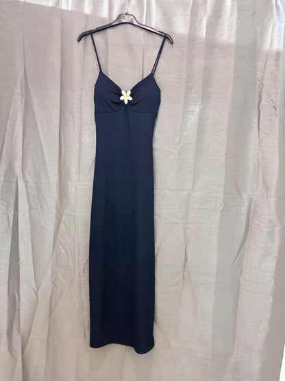 Robe longue à fines bretelles, bijou fleur au décolleté