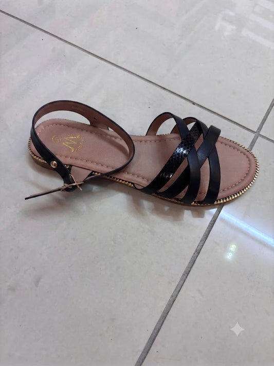 Sandale plate noire, brides croisées façon python et semelle dorée