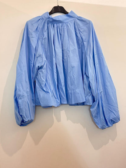 Blouse ample à col montant froncé manches ballon et dos ouvert noué en nœud