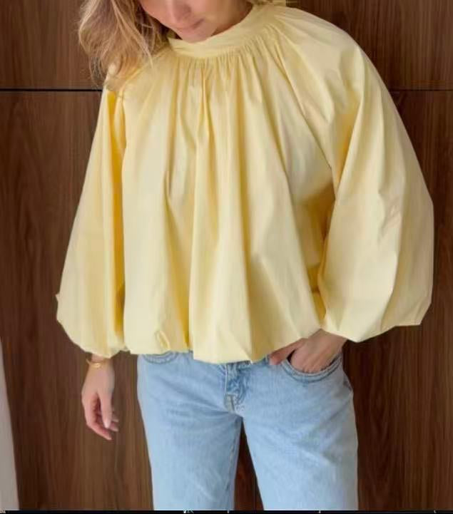 Blouse ample à col montant froncé manches ballon et dos ouvert noué en nœud