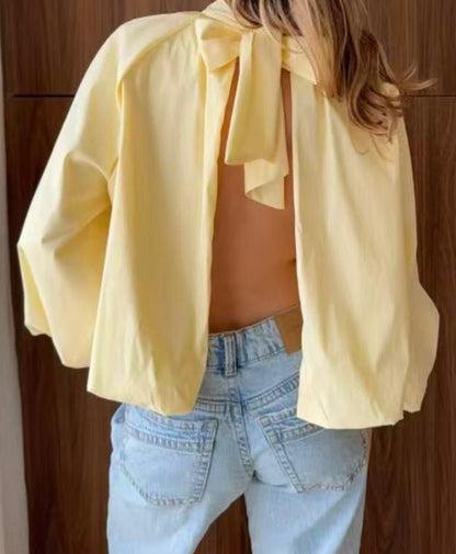 Blouse ample à col montant froncé manches ballon et dos ouvert noué en nœud