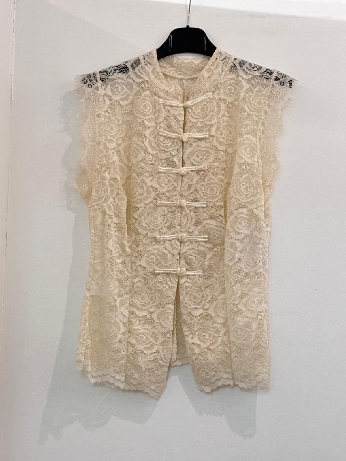 Top blanc en dentelle florale sans manches, col mao et fermeture à brandebourgs
