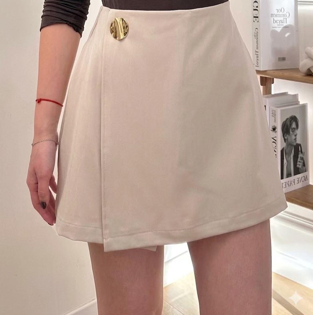 Short-jupe évasée taille haute à portefeuille asymétrique et bouton médaillon doré