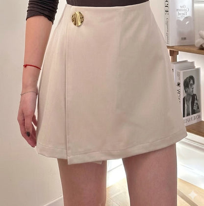 Short-jupe évasée taille haute à portefeuille asymétrique et bouton médaillon doré