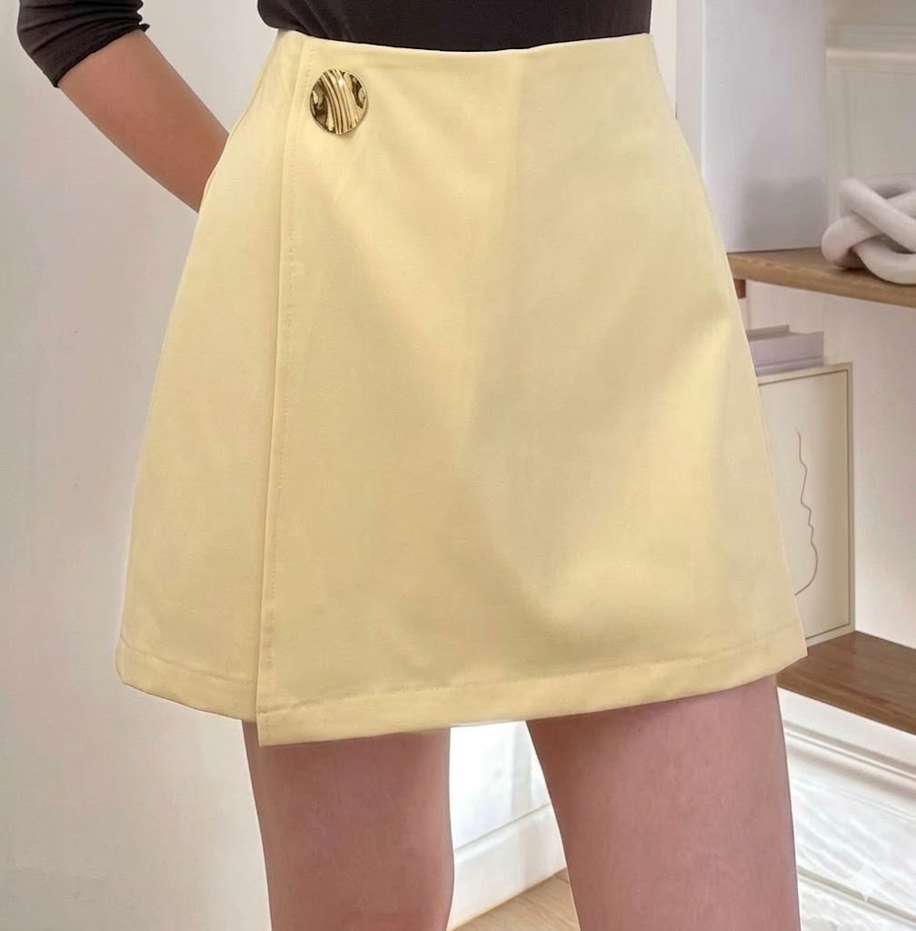 Short-jupe évasée taille haute à portefeuille asymétrique et bouton médaillon doré